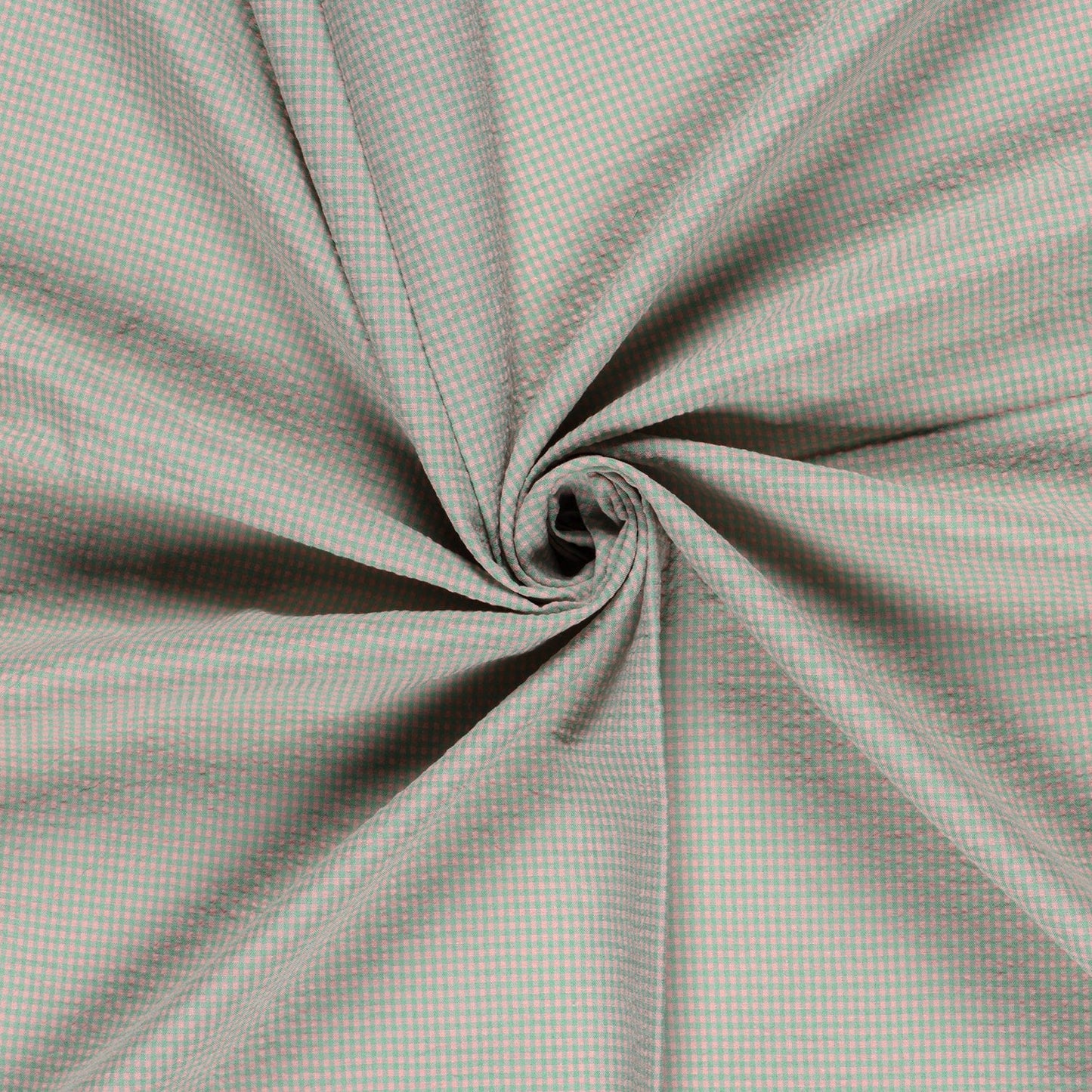A close-up of a light gray and white gingham fabric, artistically swirled into a spiral pattern to show off its drape and texture.