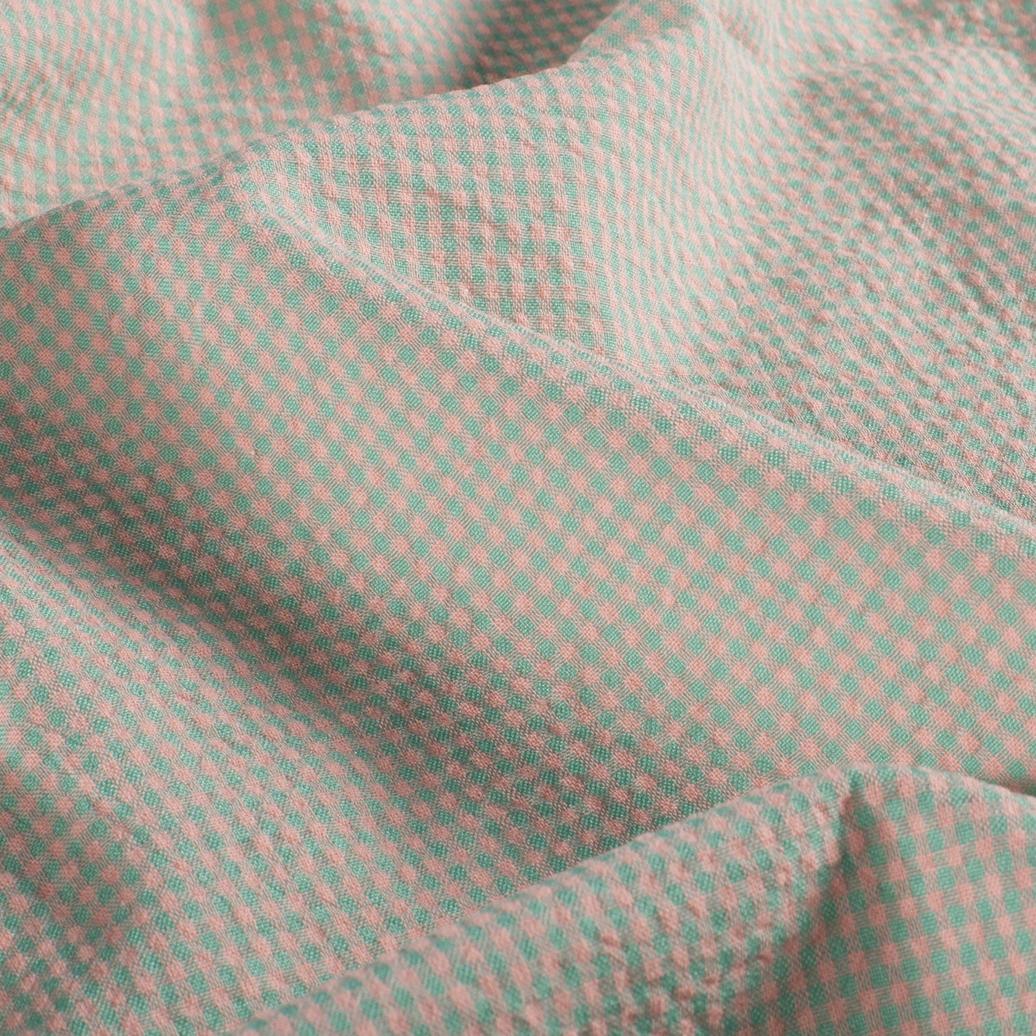 Close-up of a green and pink checkered fabric texture