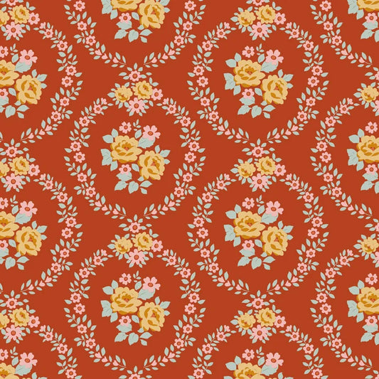A repeating floral pattern on a warm rust-orange background, featuring yellow roses, pink blossoms, pale blue leaves, and white vine motifs arranged in oval frames.