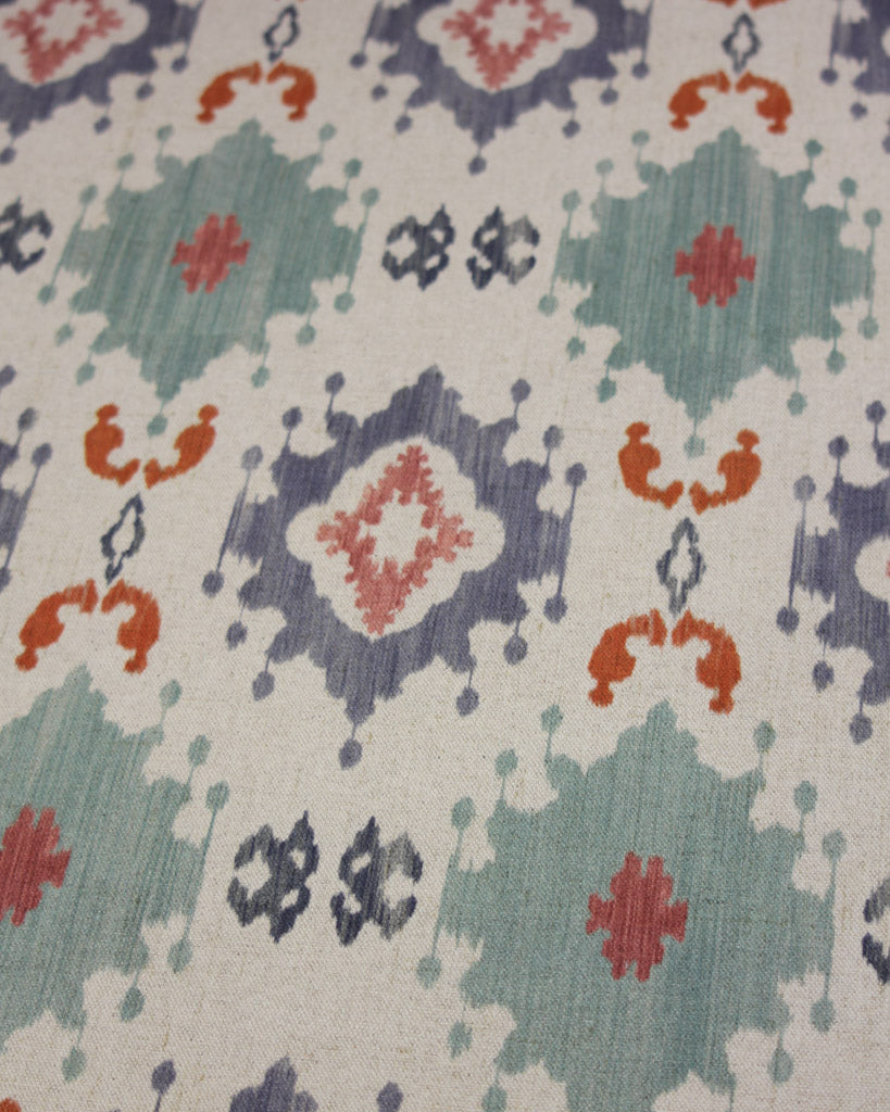 Curtain fabric with geometric design in red, blue, and green on a neutral cotton linen background