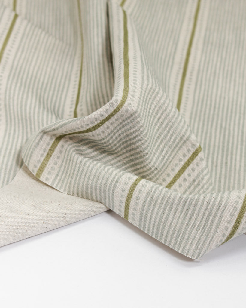 Close-up of astriped fabric with green stripes on a white background
