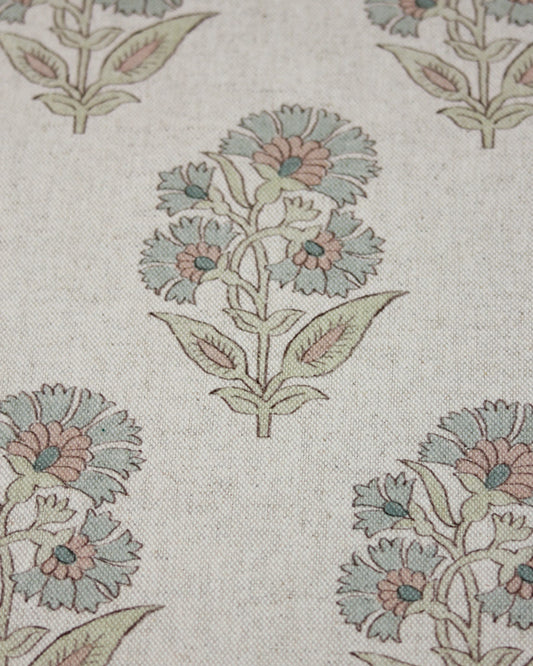 Close-up of floral patterned curtain fabric with green, pink, and brown colours on a light beige background.
