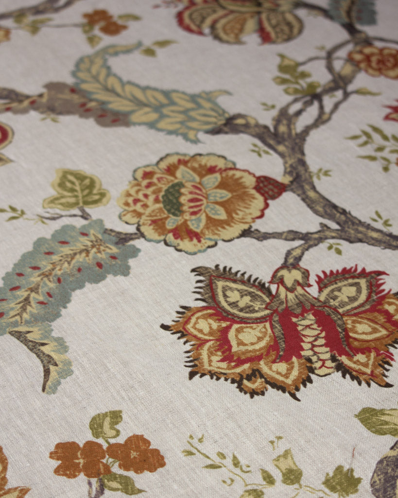 A close-up of a cotton upholstery fabric featuring stylized flowers and leaves in muted red, mustard yellow, sage green, and brown on a neutral beige background.