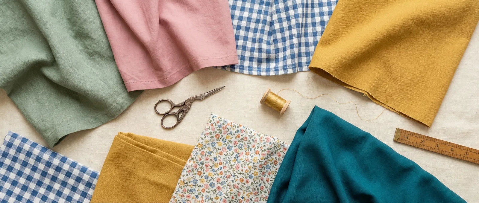 Assorted fabrics and sewing tools on a light surface