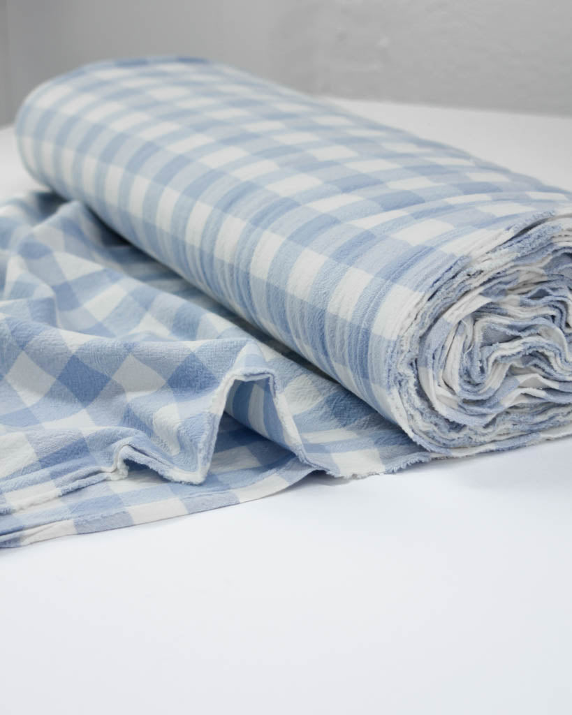 Folded blue and white checkered gingham organic cotton fabric 
