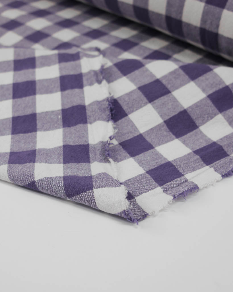 Close-up of purple and white ginghams checkered organic cotton fabric