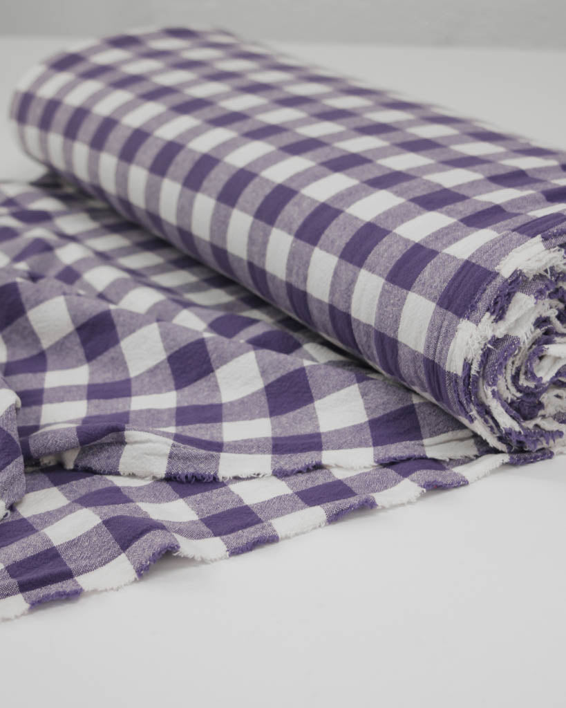 Roll of purple and white gingham checkered organic cotton fabric