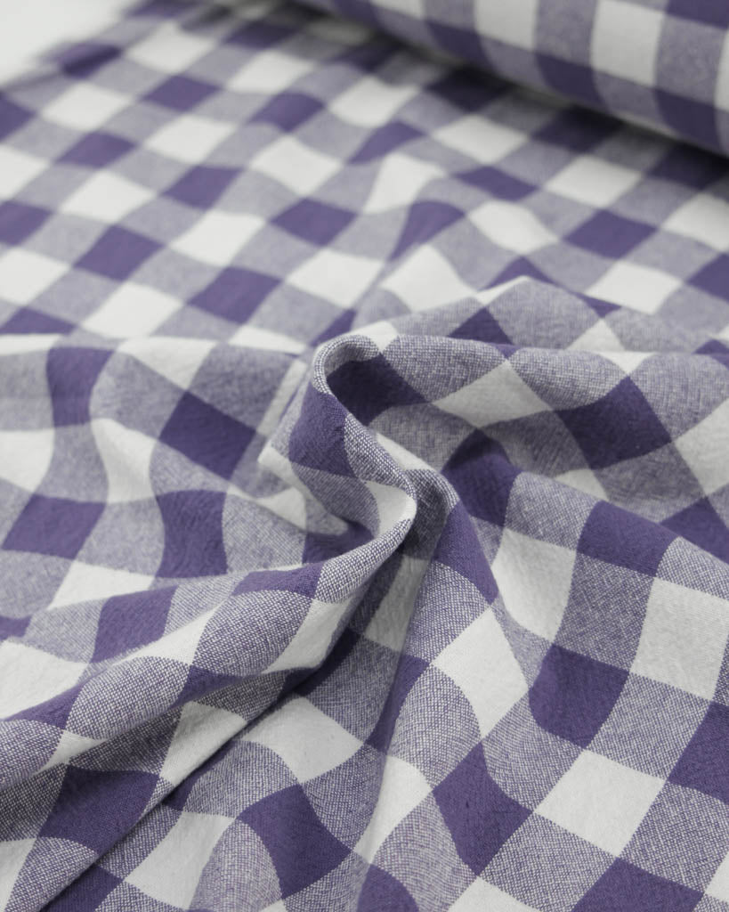 Close-up of purple and white ginghams checkered organic cotton fabric