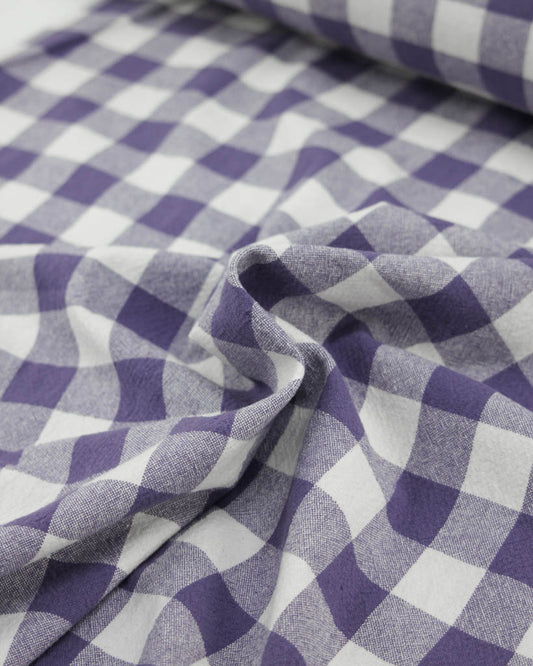 Close-up of purple and white ginghams checkered organic cotton fabric