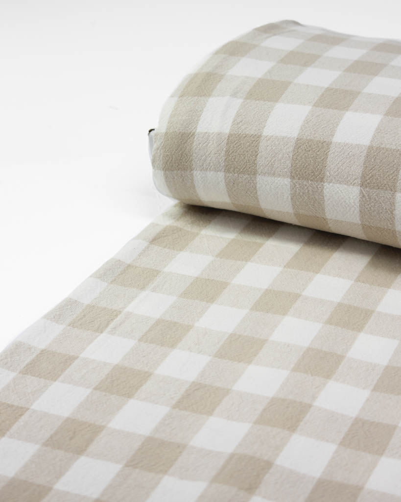 Roll of beige and white checkered fabric on a white background