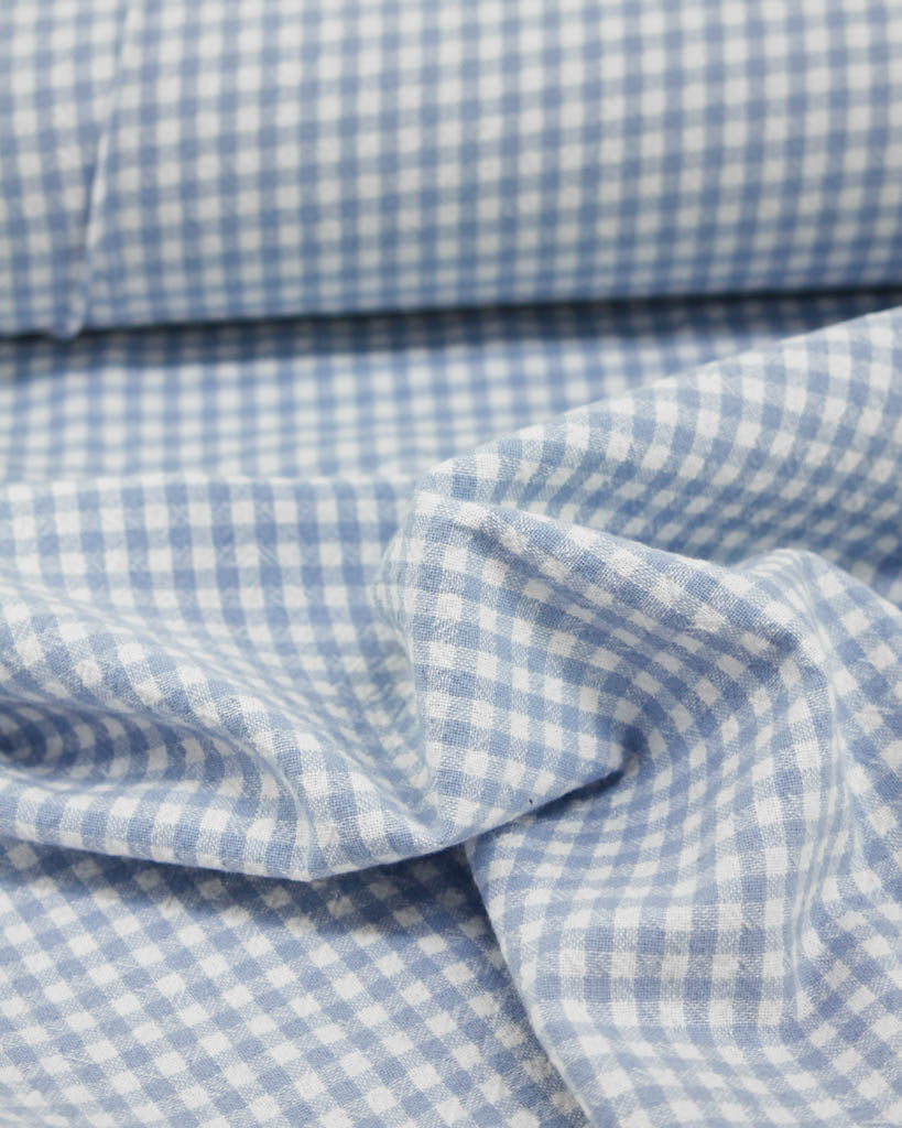 Close-up of blue and white checkered gingham organic cotton fabric