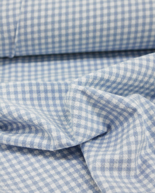 Close-up of blue and white checkered gingham organic cotton fabric