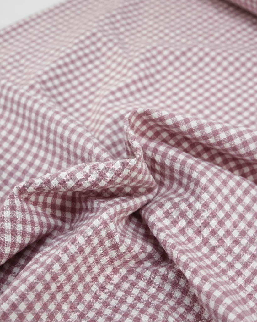 Close-up of pink and white checkered gingham organic cotton fabric