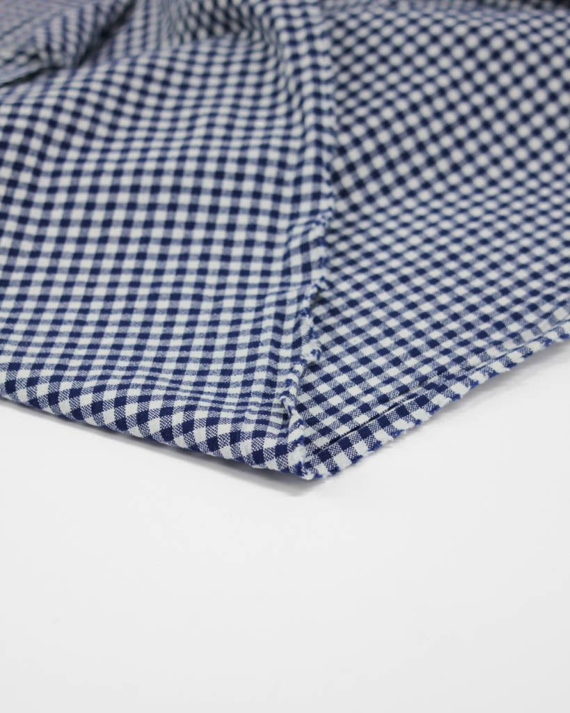 Flipped edge of royal blue and white organic cotton gingham fabric