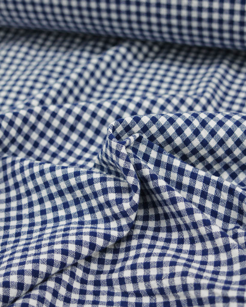 Close up of royal blue and white organic cotton gingham fabric