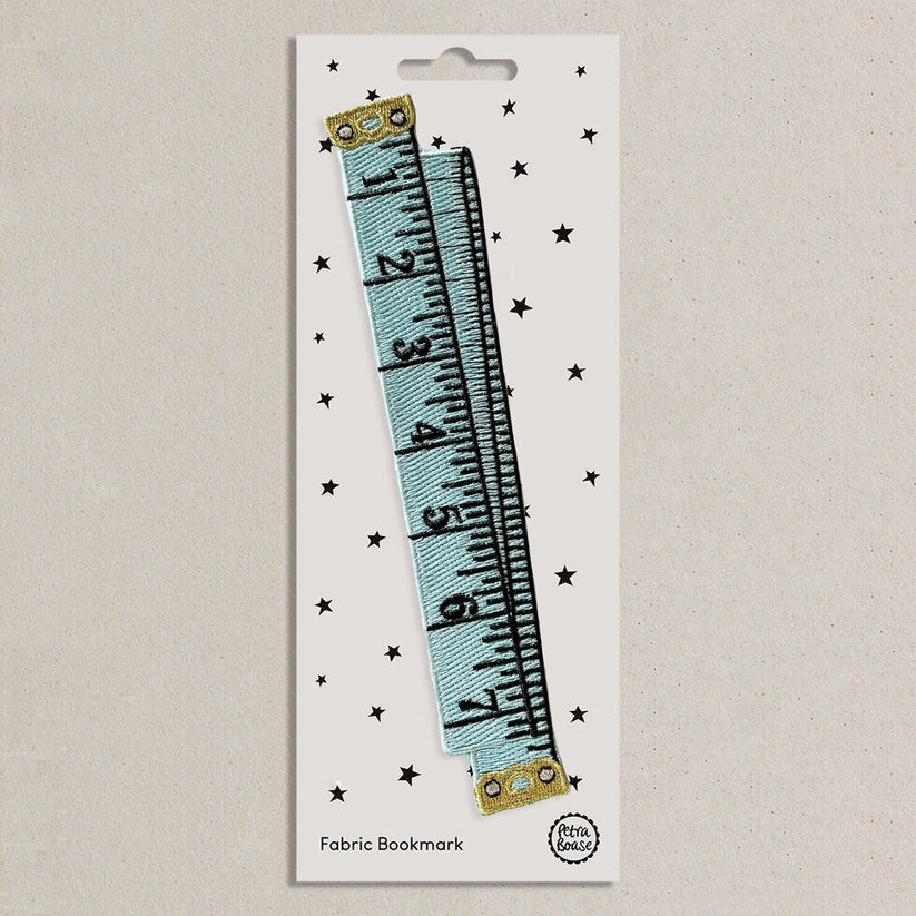 Fabric bookmark with blue tape measure design on a white presentation card 