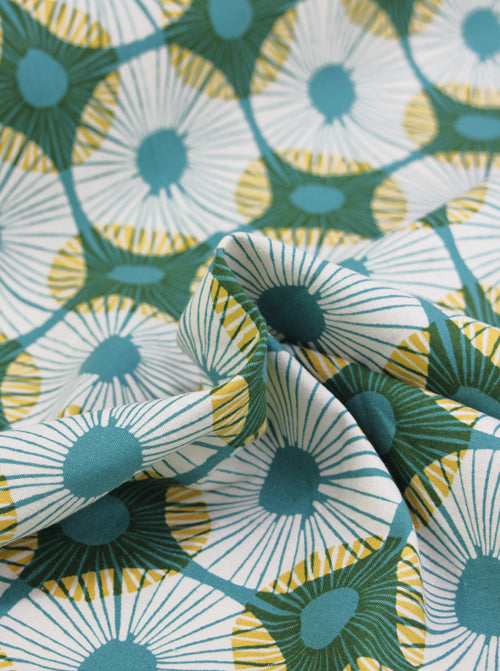 Close-up of fabric with a floral pattern featuring green, white, and yellow colors.