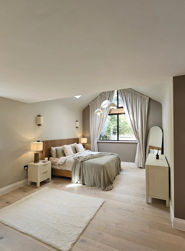 Modern bedroom with wooden bed, side tables, and large window.