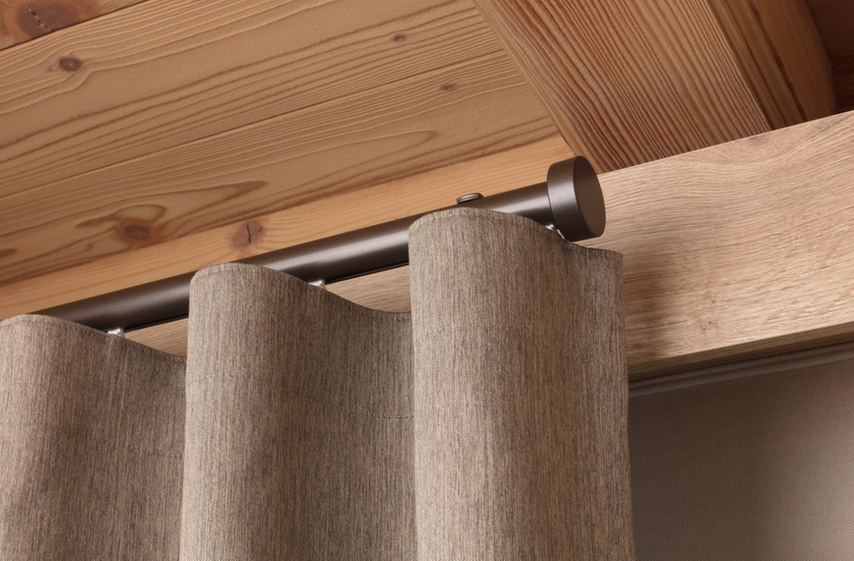 Ceiling-mounted curtain track with natural fabric curtains