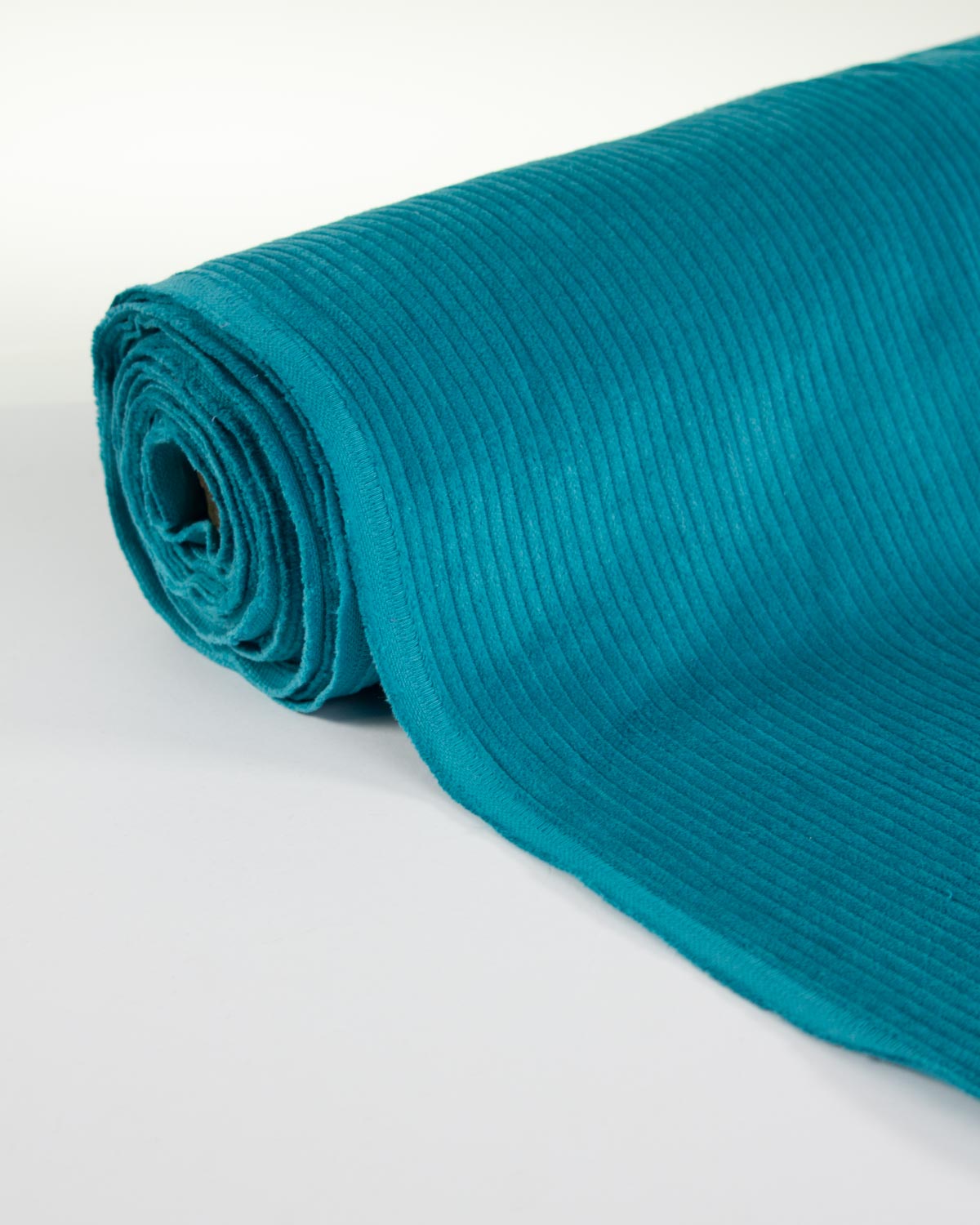 A rolled turquoise blue cotton corduroy fabric showing its ribbed texture, on a clean white background.