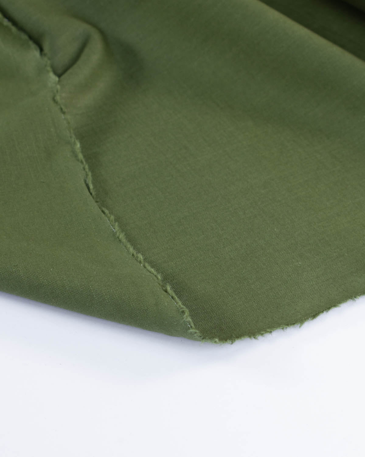 Selvedge edge close up of olive green linen fabric