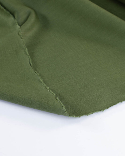 Selvedge edge close up of olive green linen fabric